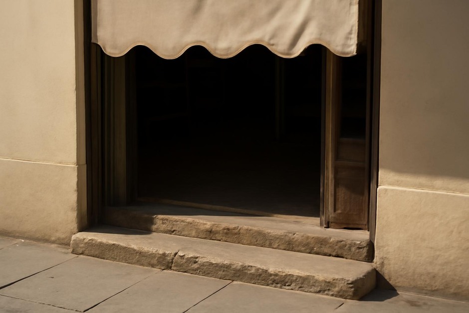 Threshold between street and shop with worn step and awning